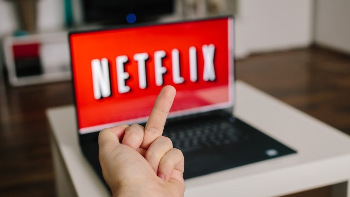 Usuário fazendo gesto obsceno em meio a logo da Netflix