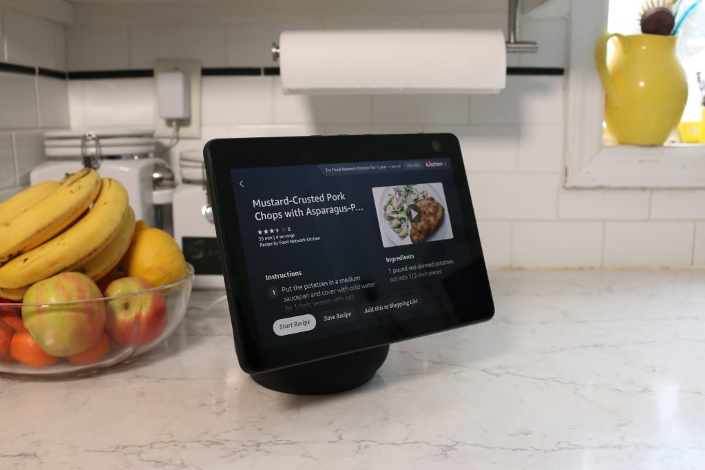 Echo Show 10 em uma mesa, ao lado de um cesto de frutas.